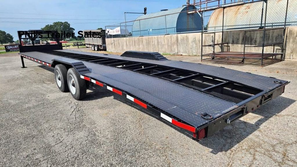 2021 Texas Pride 102X40 open car hauler trailer in black, driver side profile view.